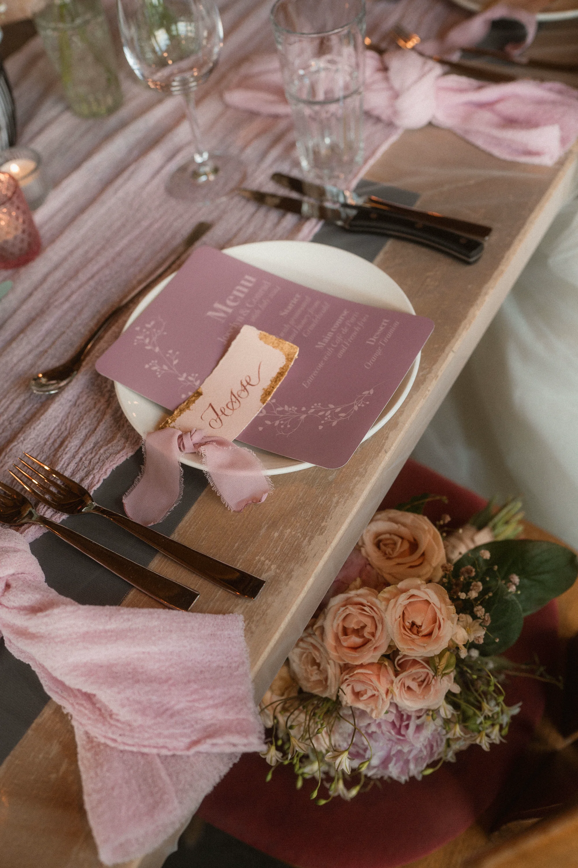 Blush wedding place setting with a hand-lettered name card and menu